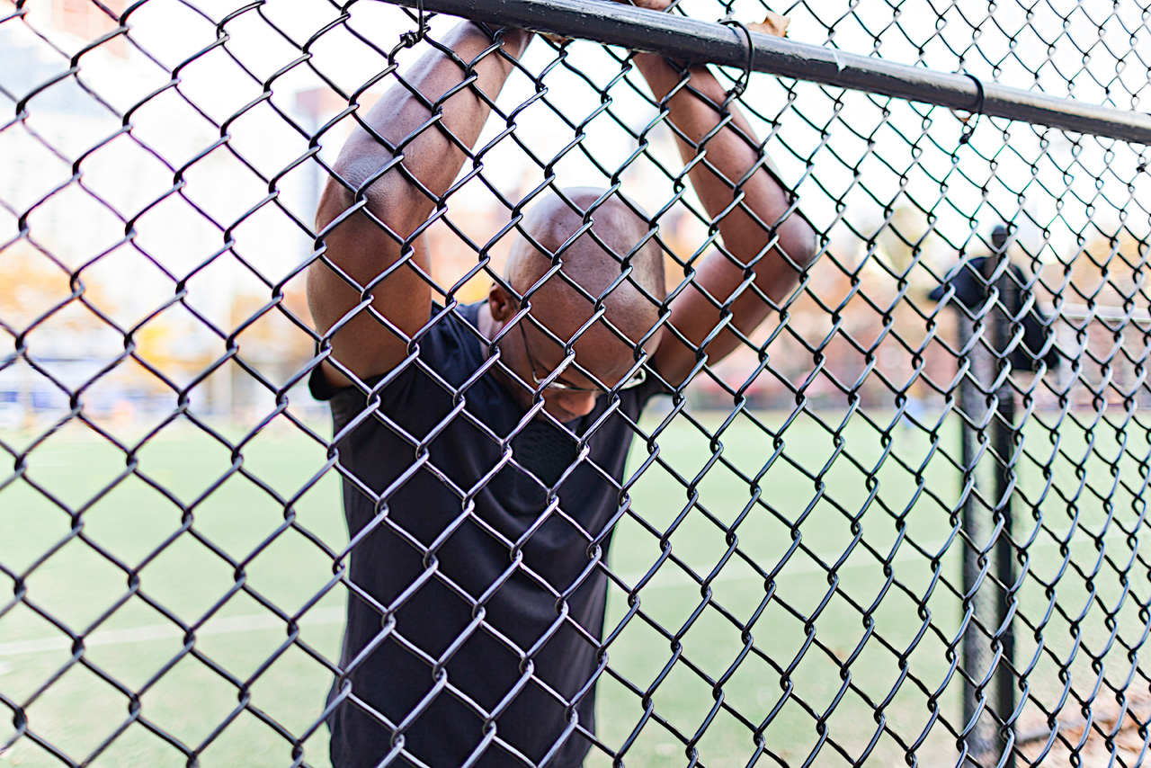 a man behind the chain wire fence